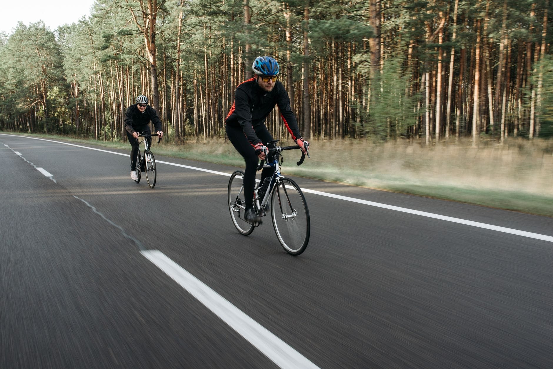Dwóch rowerzystów jedzie leśną drogą podczas rekreacyjnej przejażdżki