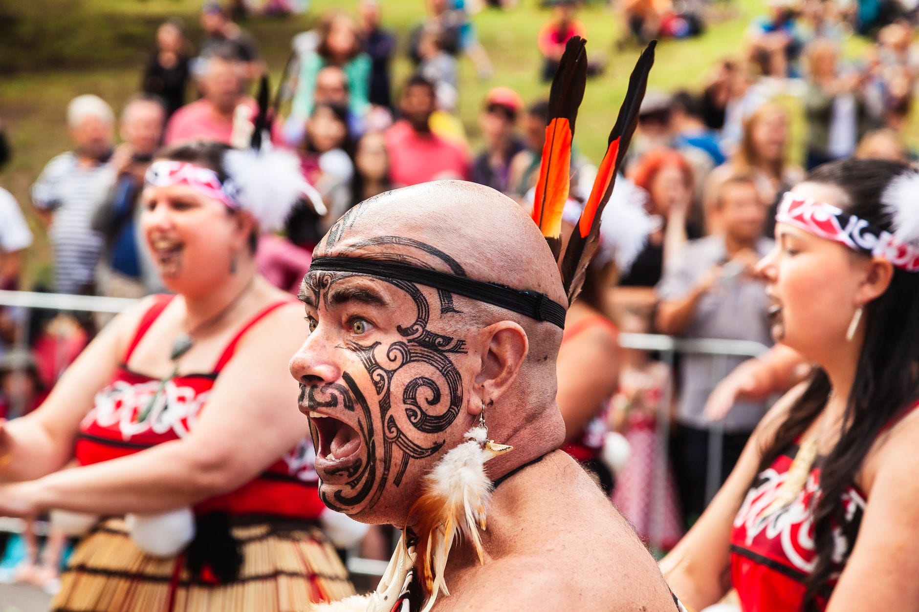 Maoryski performer z pomalowaną twarzą podczas dziennego festiwalu