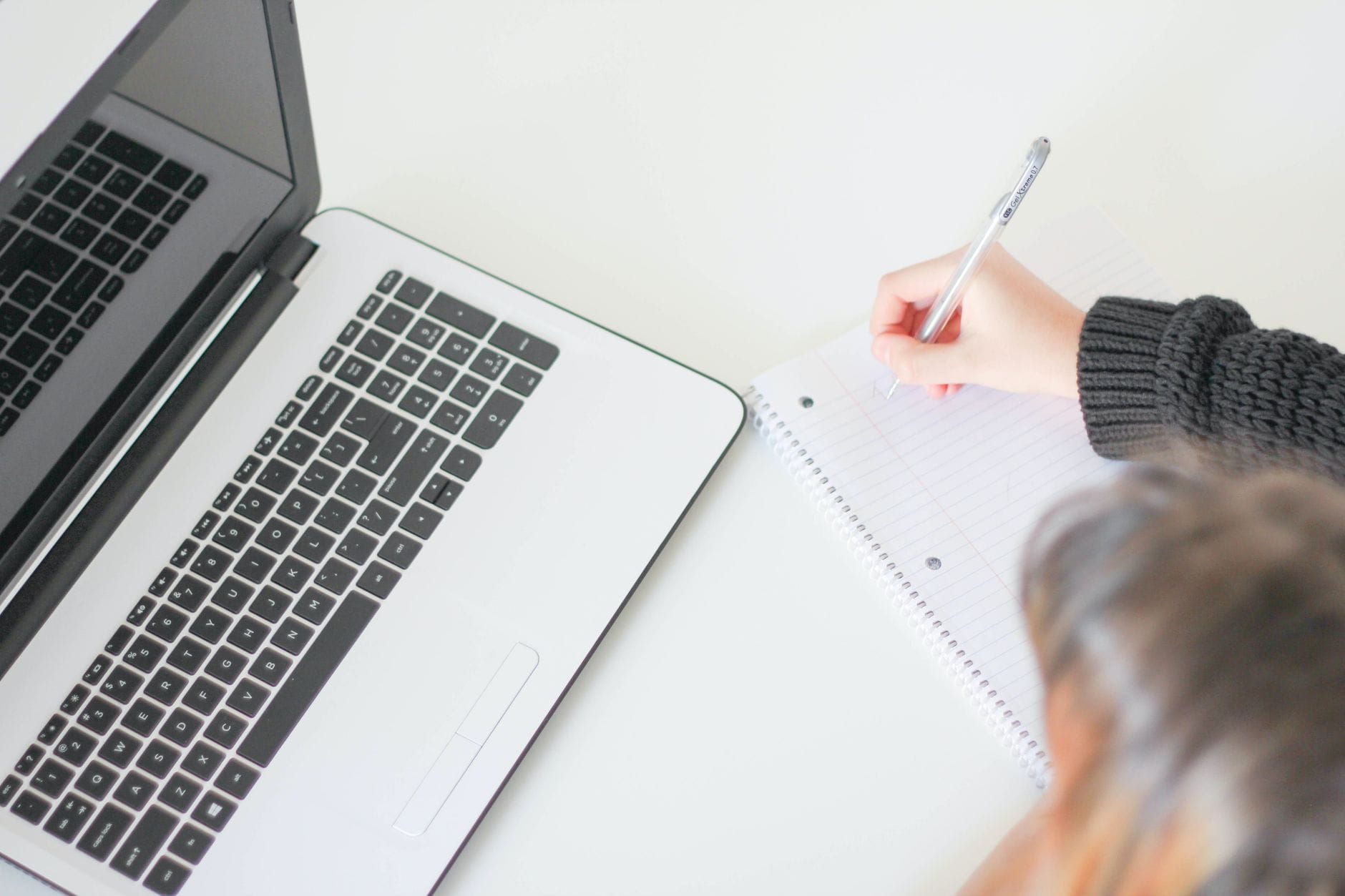 Laptop i notes na domowym biurku podczas pisania pierwszego wpisu blogowego
