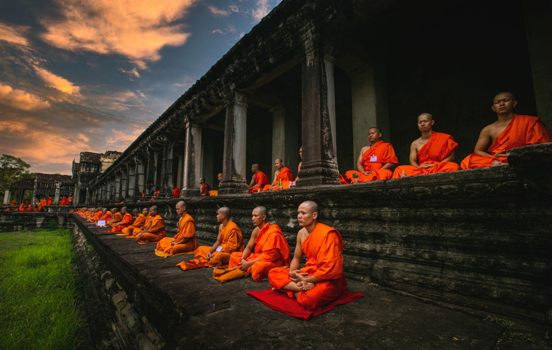 Mnisi buddyjscy medytują o zachodzie słońca przy świątyni Angkor Wat