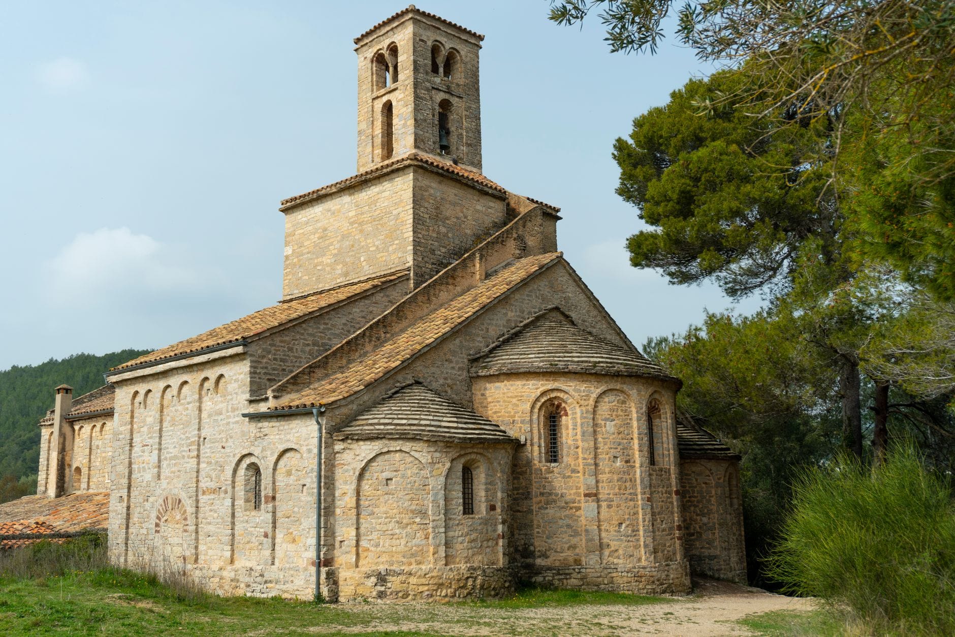 Romański kamienny kościół wśród drzew w Corbera de Llobregat, Katalonia